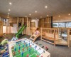 Detská herňa s drevenými preliezkami a stolným futbalom, kde sa hrajú deti.  