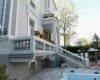 Sivá budova s balkónom a prázdnym bazénom v popredí.