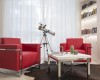 Dve červené kreslá a teleskop vedľa stola s kaktusmi a knihami v modernom obývacej izbe.