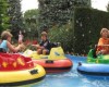 Deti riadia farebné nárazníkové člny na vodnej atrakcii vonku.