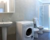 Kúpeľňa s práčkou, umývadlom, toaletou a sprchovacím kútom.