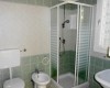 Kúpeľňa so sprchovacím kútom, toaletou, bidetom a umývadlom.