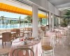 Reštaurácia s výhľadom na bazén, stoly pripravované na raňajky.