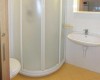 Kúpeľňa so sprchovým kútom, umývadlom a toaletou.