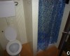 Kúpeľňa s toaletou a modrým sprchovým závesom.