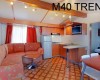 Interiér mobilného domu s kuchynským kútom, sedacou súpravou a nápisom M40 TREND.