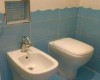Bidet a toaleta v kúpeľni s modro-bielymi dlaždičkami.