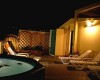 Terasa s lehátkami a vírivkou osvetlená nočným svetlom.  