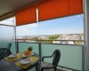 Balkón s výhľadom na mesto a more, okrúhly stôl s dvoma stoličkami.