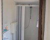 Malá kúpeľňa so sprchovacím kútom, umývadlom a toaletou.
