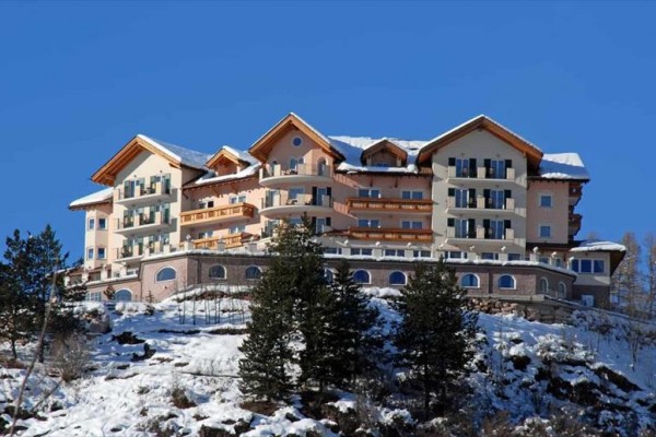 Luxusný hotel na zasneženej hore oproti modrej oblohe.