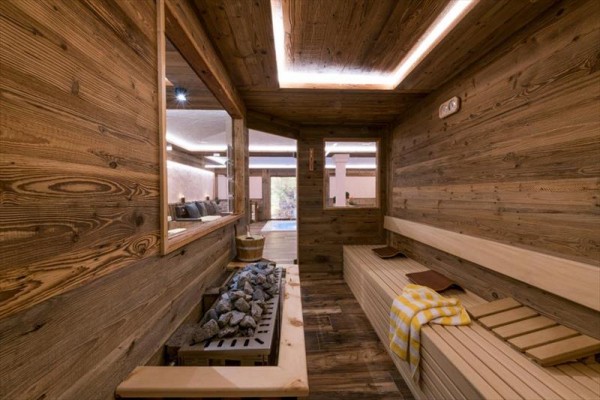 Sauna s dreveným interiérom, lavicami a vyhrievacími kameňmi.