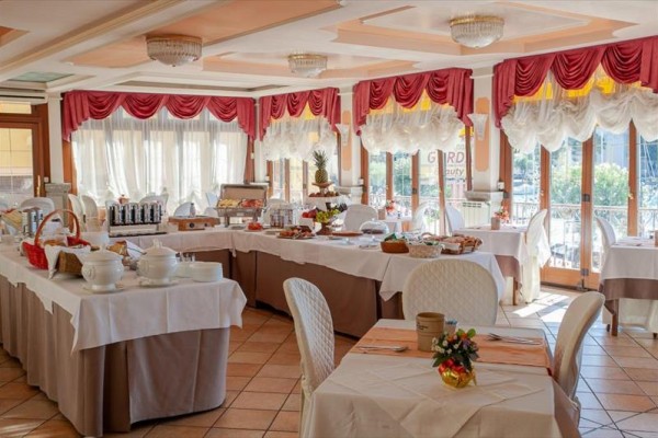 Elegantná hotelová jedáleň s pripraveným bufetom na stoloch.