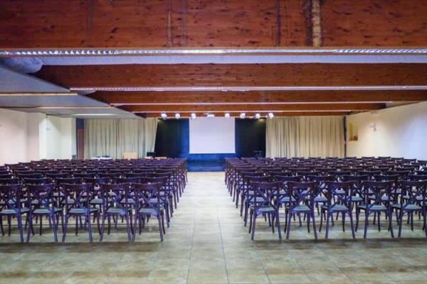Prázdna konferenčná miestnosť so stoličkami a projekčným plátnom.