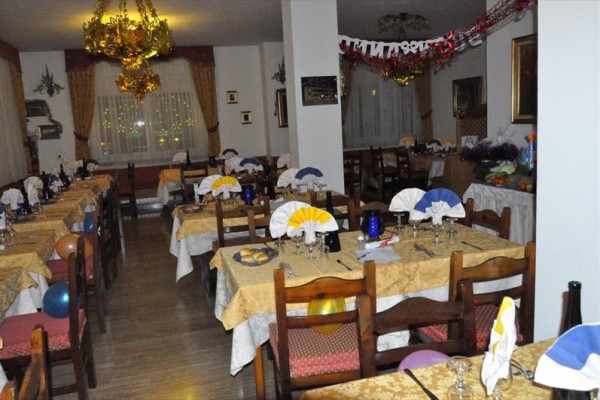 Slávnostne prestretá reštaurácia s balónmi a dekoračnými obrusmi.