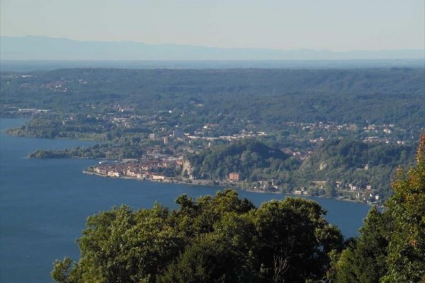 Pohľad na mesto pri jazere obklopené lesmi a kopcami.