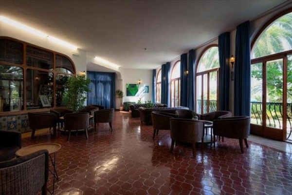 Elegantná hotelová lobby s veľkými oknami a pohodlnými kreslami.