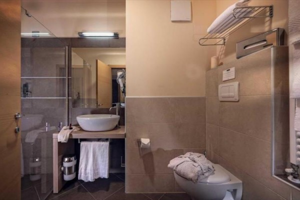 Moderná kúpeľňa s umývadlom, toaletou a sprchovacím kútom.