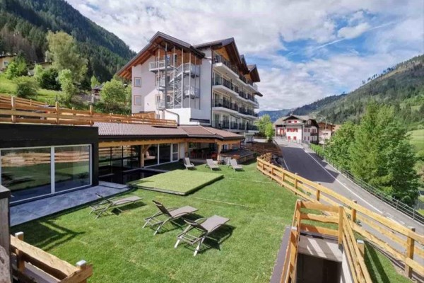 Hotel s priestrannou záhradou a lehátkami v horskej krajine.