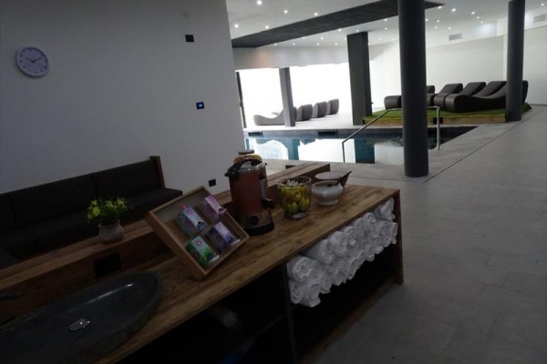 Interiér wellness centra s relaxačnými ležadlami a bazénom.