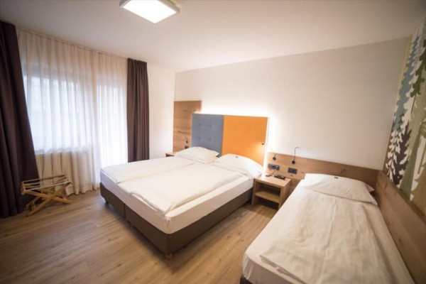 Hotelová izba s manželskou posteľou a jednolôžkom.