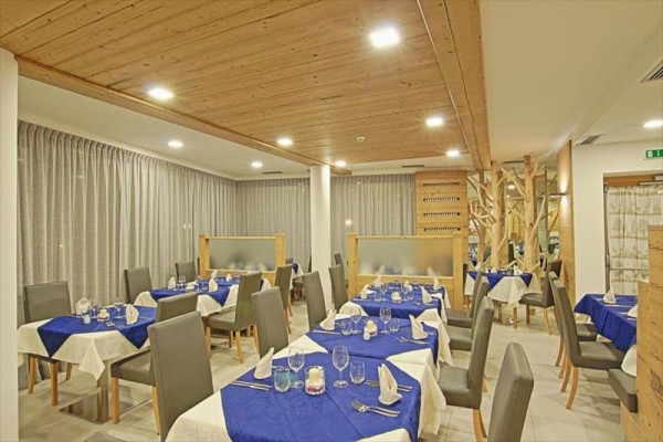 Moderne zariadená reštaurácia s bielymi a modrými obrusmi na stoloch.