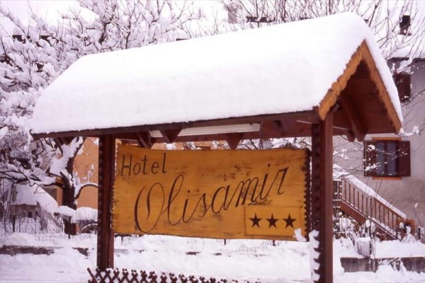 Drevená tabuľa hotela s tromi hviezdičkami, pokrytá snehom.