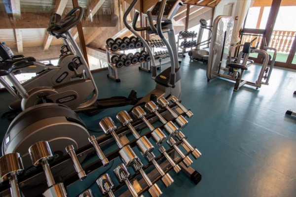Posilňovňa s činkami a fitness strojmi.