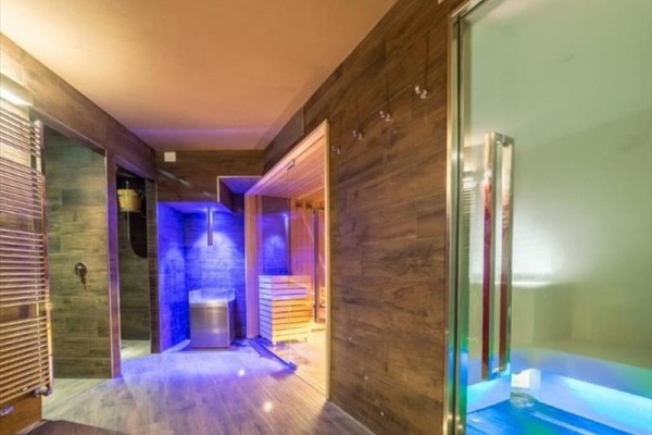 Moderné wellness s dreveným obložením, saunou a farebným osvetlením.