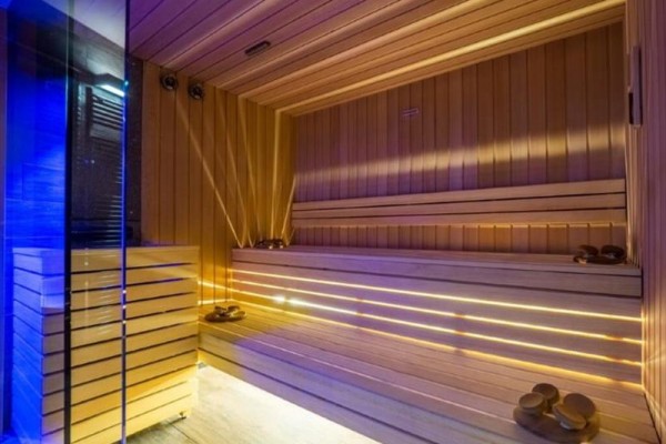 Moderná sauna s dreveným obkladom a osvetlením.