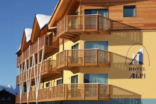 Moderný hotel s drevenými balkónmi za slnečného počasia.