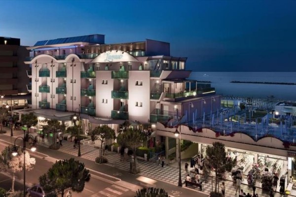 Moderný hotel pri mori vo večernom osvetlení.