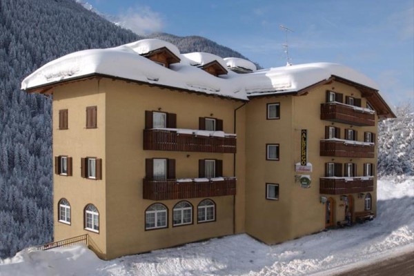 Trojposchodový hotel v zasneženej horskej krajine.