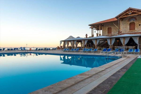 Luxusný hotel pri vonkajšom bazéne počas súmraku.