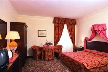 Luxusná hotelová izba s veľkou posteľou a elegantným nábytkom.