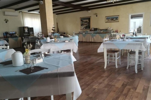 Reštaurácia s drevenou podlahou a modro-bielymi obrusmi na stoloch.