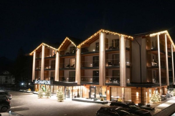 Moderný horský hotel v tme osvetlený vianočnými svetlami.