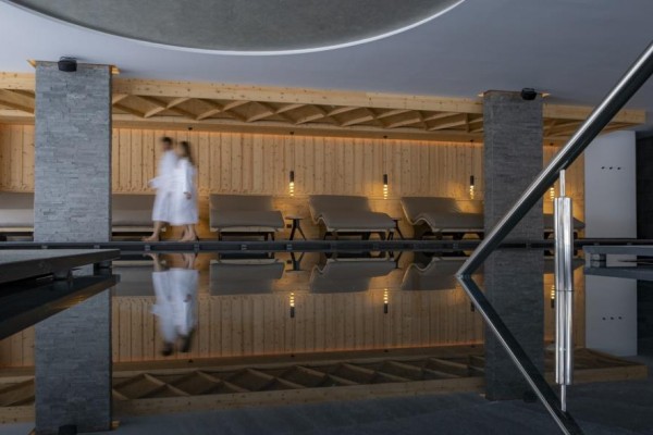 Relaxačná zóna s ležadlami a bazénom v modernom spa interiéri.