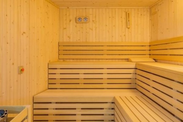 Drevená sauna s lavicami a pieckou.  