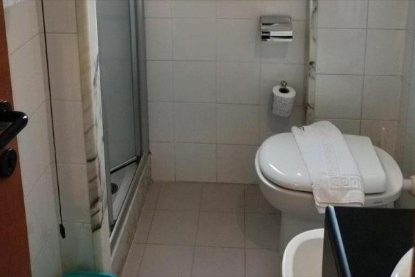 Kúpeľňa s toaletou, sprchovým kútom a umývadlom.