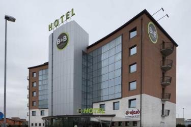 Moderný viacposchodový hotel B&B s presklenou fasádou a hnedými tehlovými stenami.