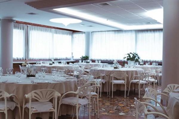 Elegantná reštaurácia s okrúhlymi stolmi a bielymi stoličkami pripravená pre hostí.