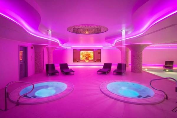 Luxusné wellness centrum s vírivkami a ružovým osvetlením.
