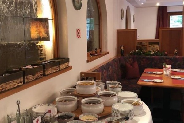 Jedálenský stôl v reštaurácii s rôznymi nádobami a taniermi pripravenými na servírovanie jedla.