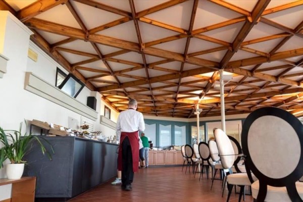 Elegantný interiér reštaurácie s dreveným stropom a okrúhlymi stoličkami.