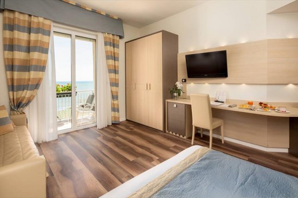 Moderná hotelová izba s balkónom a výhľadom na more.