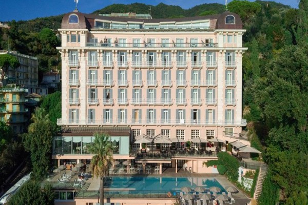 Veľký hotel sa nachádza v hornatej oblasti s bazénom v popredí.