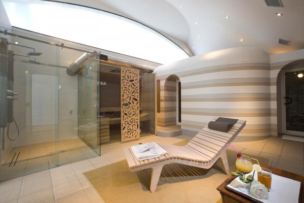 Moderné kúpeľné wellness so saunou a lehátkom.