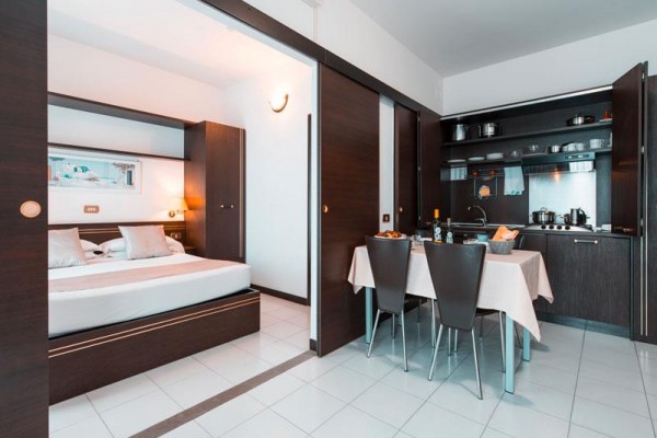 Moderný apartmán so spálňou a kuchynským kútom.