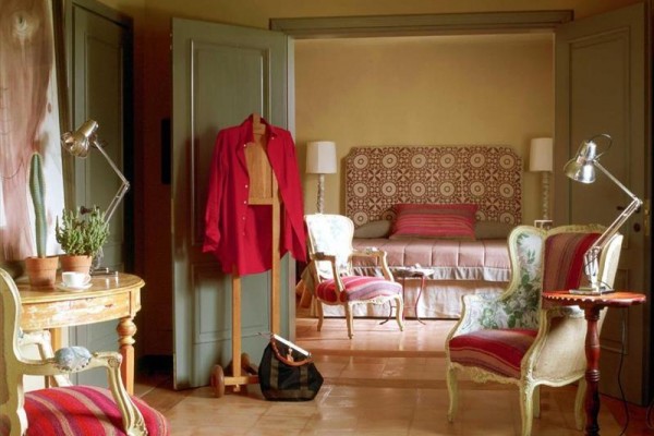 Elegantný interiér s vintage nábytkom a otvorenými dverami vedúcimi do spálne.